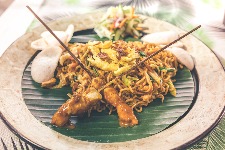 Chicken satay noodle dish on a bamboo leaf freshly served