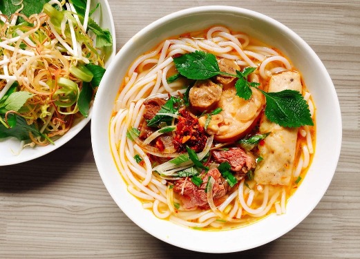 Top down view of a fresh bowel of noodles with lettace on the side